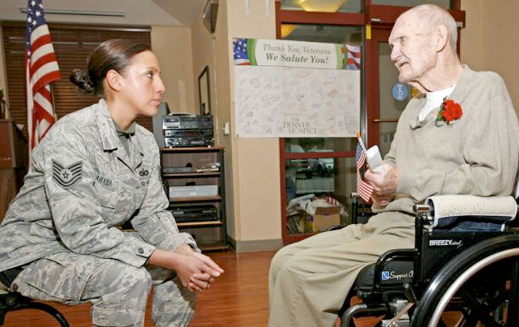 Young vet talking to an older vet who is in a wheelchair